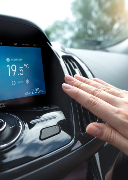 Car air conditioning. Woman checks air conditioning in a car
